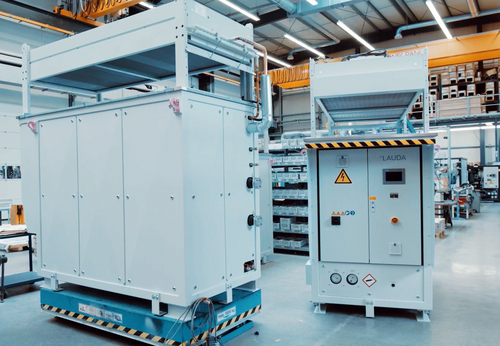 LAUDA continues to expand the production capacities for the SUK secondary circuit units required for cooling the hydrogen before the refueling process. Two SUK units in a production hall, one is at right angles to the viewer on the left of the picture, the other shows its front and is on the right of the picture.