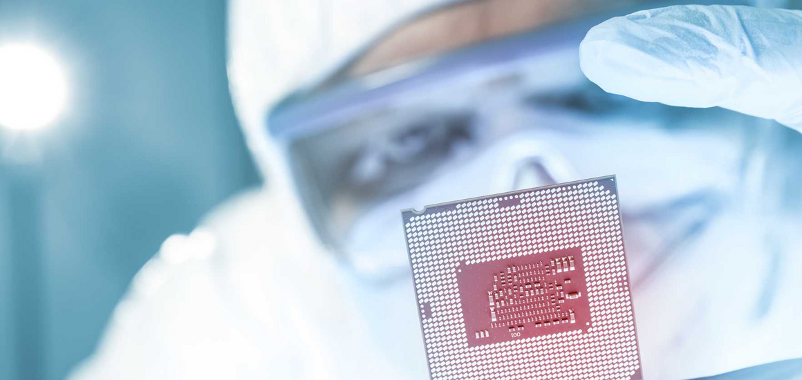 A person looks at a semiconductor wafer up close