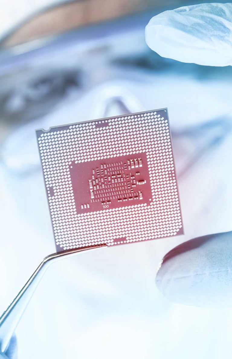 A person looks at a semiconductor wafer up close